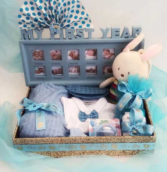 Baby hamper with Baby clothes, teddys and powders, blue coloured with the tag My first year