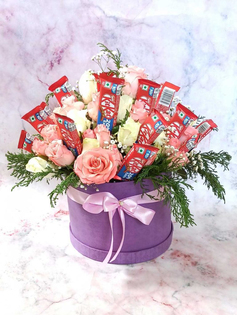 A basket of kitkat bars with yellow and pink flowers