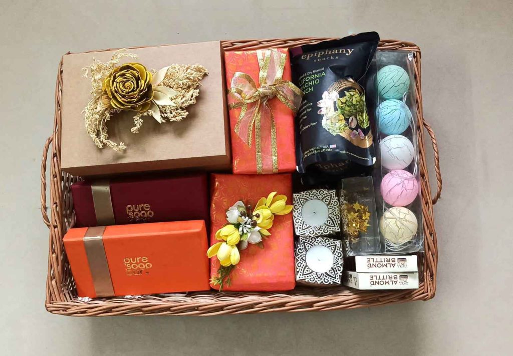 Brown basket with multiple wrapped gifts, snacks and candles