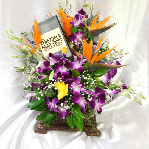 Flower pot with Violet flowers and a Bar of chocolate