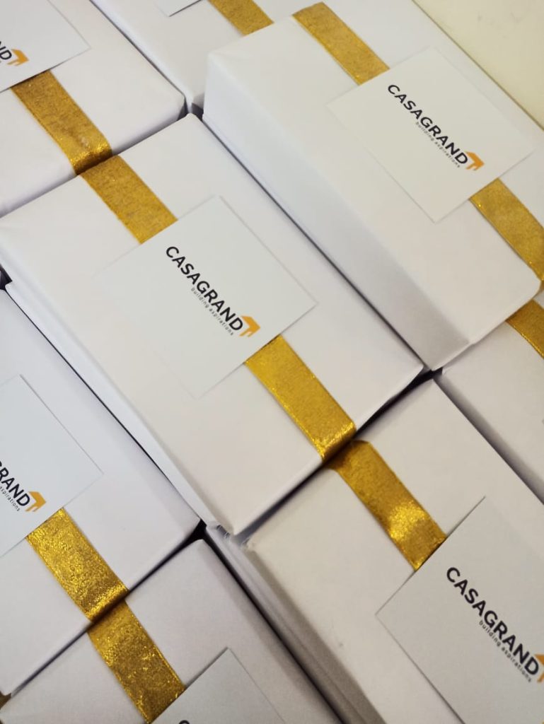 White cardboard box with golden ribbon and Casagrand logo